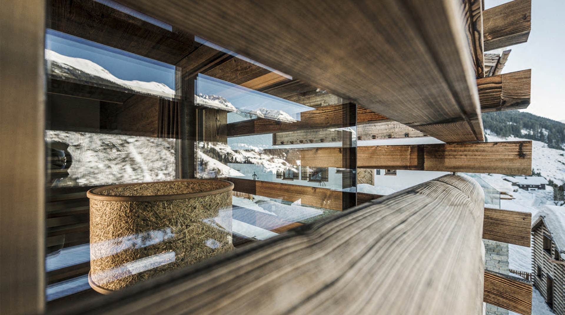 Ein Lampenschirme aus purem Heu und Holz im Bergwiesenglueck Chaletdorf hinter einem Fenster