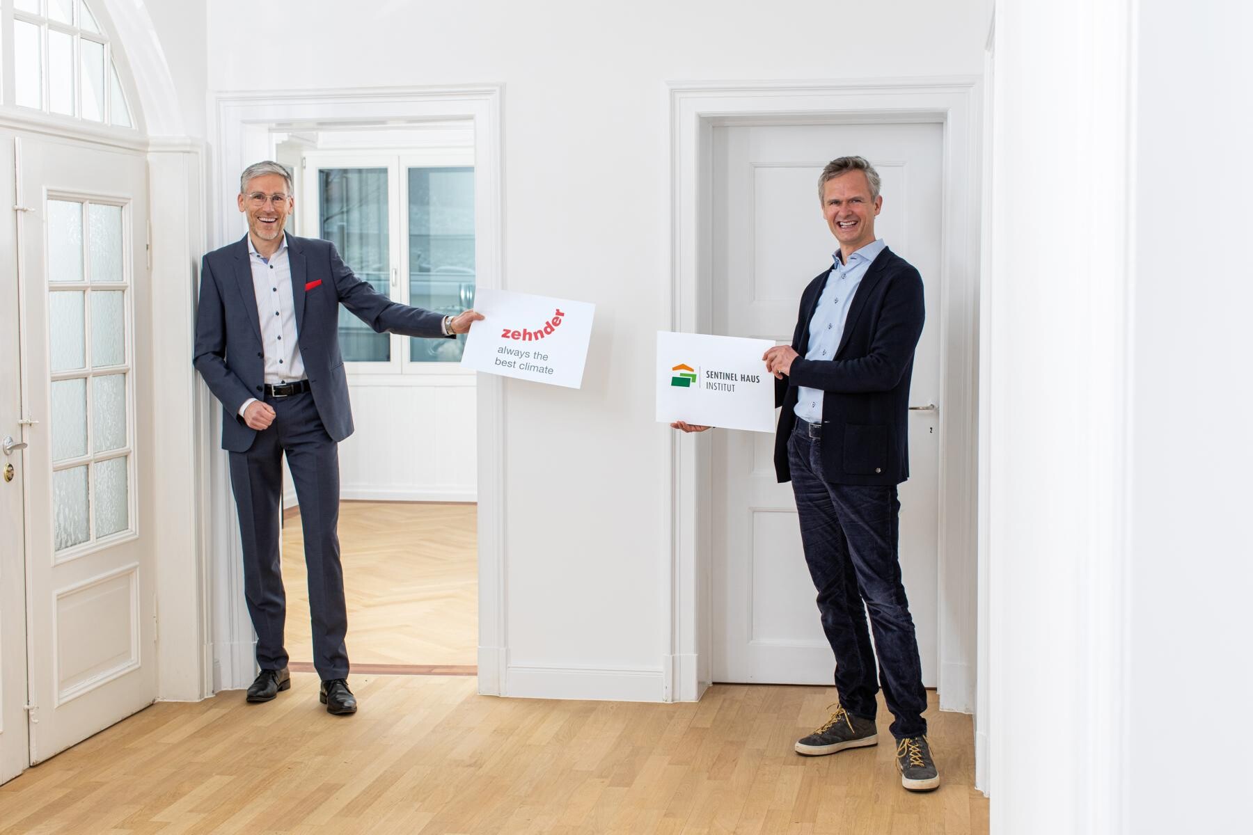 Gute Luft für gesündere Gebäude: Heiko Braun, Geschäftsführer Zehnder Deutschland, und Peter Bachmann, Geschäftsführer Sentinel Haus Institut, freuen sich auf ihre Zusammenarbeit. Foto: SHI/ Britt Schilling 