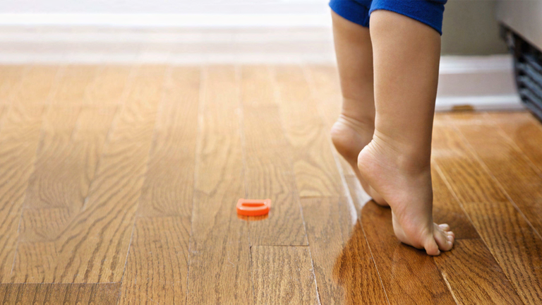 Kinderfüße auf Holzfußboden